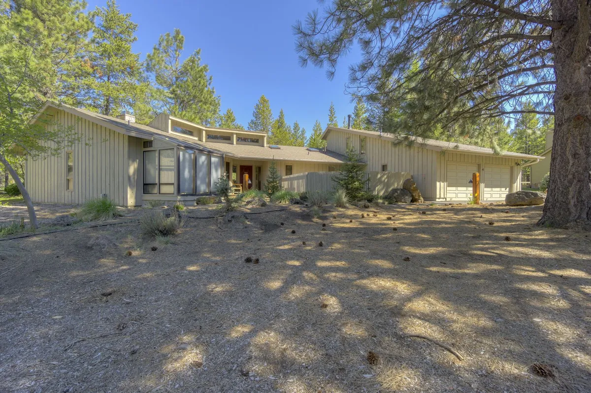 This exterior shot showcases the home’s modern architecture, the inviting front entrance, and a backdrop of trees—emphasizing the property’s welcoming presence and its setting among nature. The space hints at the garage area and the easy launching point for outdoor adventures.